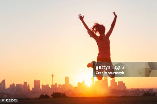 donne dello sport che saltano e festeggiano con le braccia alzate. - motivazione foto e immagini stock
