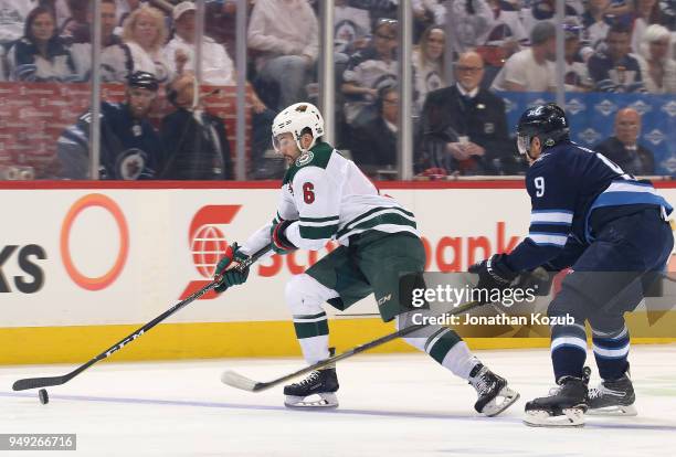 Ryan Murphy of the Minnesota Wild plays the puck down the ice as Andrew Copp of the Winnipeg Jets gives chase during first period action in Game Five...