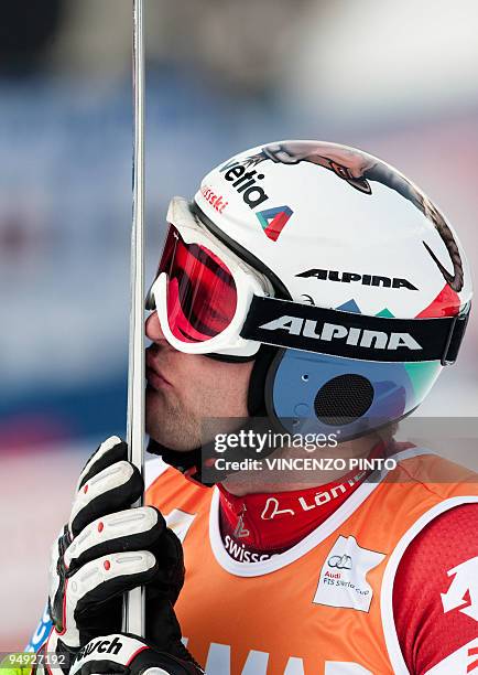 Swiss Ambrosi Hoffmann kisses his skis after taking the third place of the men's World Cup downhill race in Val Gardena on December 19, 2009....