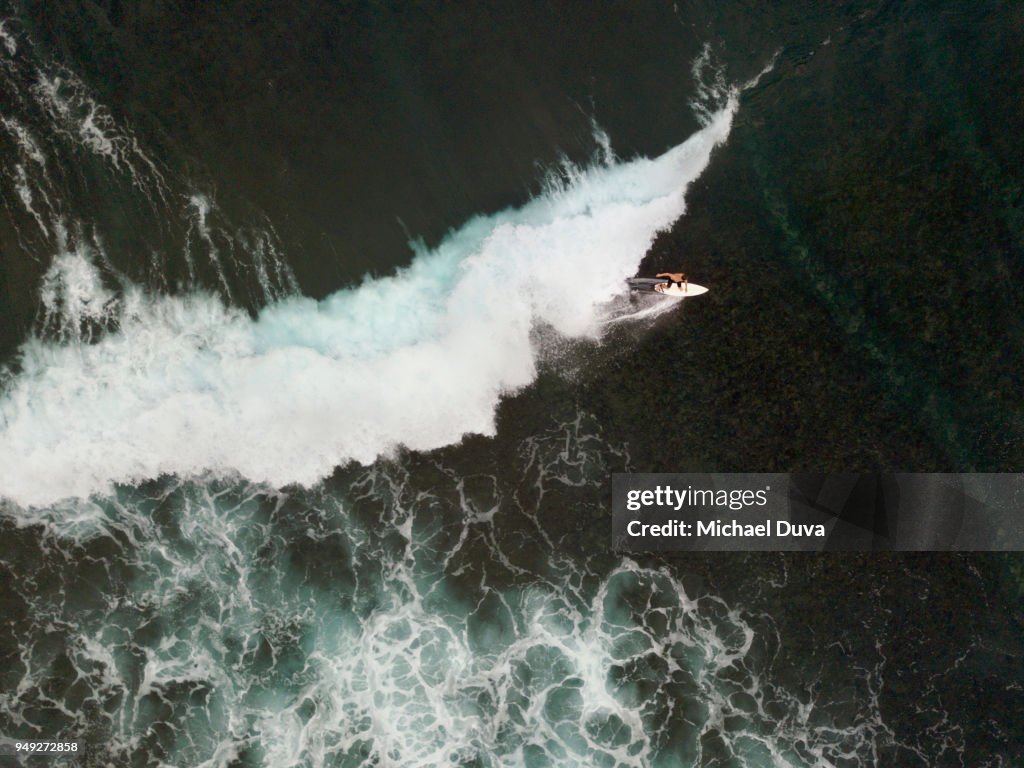 Aerial View of Surfer surfing waves