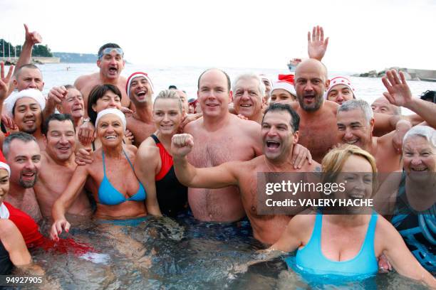 Prince Albert II of Monaco e Albert II of Monaco flanked by his girlfriend, South African swimmer Charlene Wittstock, pose with other swimmers as...