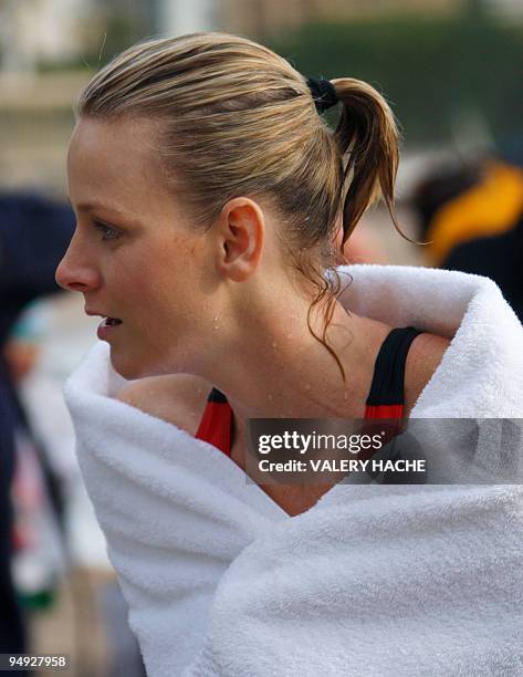 Prince Albert II of Monaco's girlfriend, South African swimmer Charlene Wittstock, wraps herself in a robe after bathing in the Mediterranean sea on...