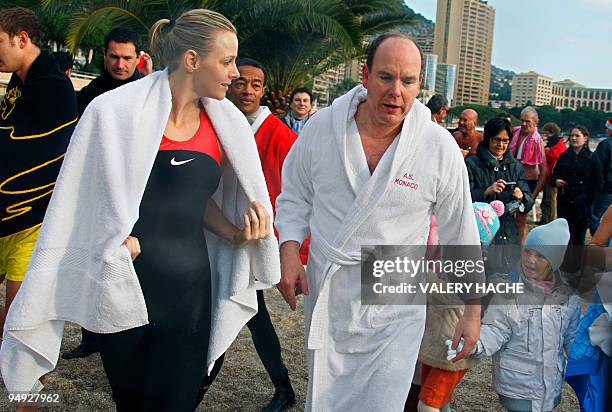 Prince Albert II of Monaco and his girlfriend, South African swimmer Charlene Wittstock, are wrapped in a robe after bathing in the Mediterranean sea...