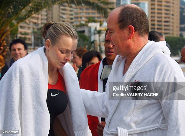 Prince Albert II of Monaco and his girlfriend, South African swimmer Charlene Wittstock, are wrapped in a robe after bathing in the Mediterranean sea...