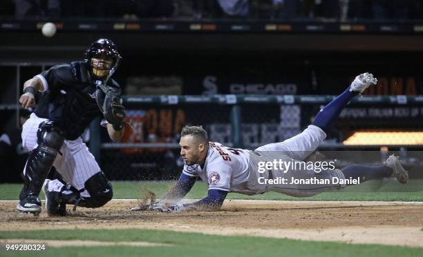 George Springer of the Houston Astros dives in to score a run as Omar Narvaez of the Chicago White Sox takes a late throw in the 4th inning at...