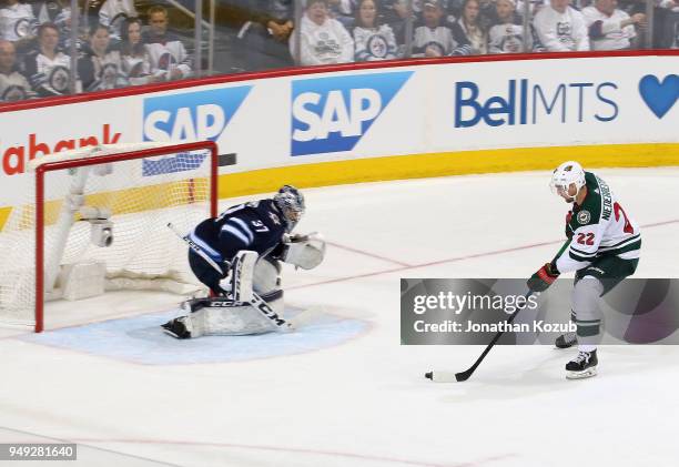 Nino Niederreiter of the Minnesota Wild carries the puck in on goaltender Connor Hellebuyck of the Winnipeg Jets during second period action in Game...