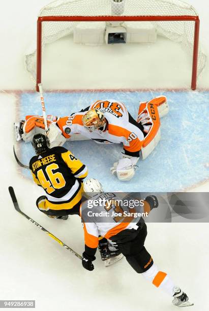 Michal Neuvirth of the Philadelphia Flyers makes a save on Zach Aston-Reese of the Pittsburgh Penguins in Game Five of the Eastern Conference First...