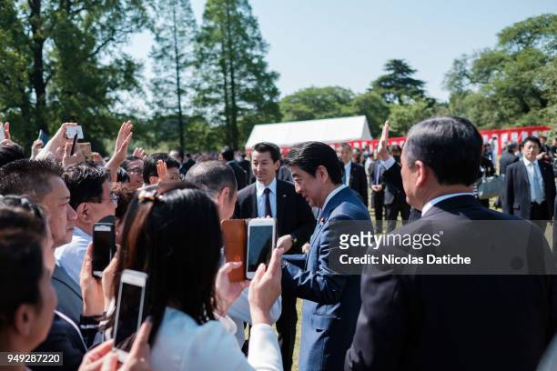 Japan Prime Minister Shinzo Abe shakes hands with guests during a government garden party in Shinjuku Gyoen park on April 21, 2018 in Tokyo, Japan....