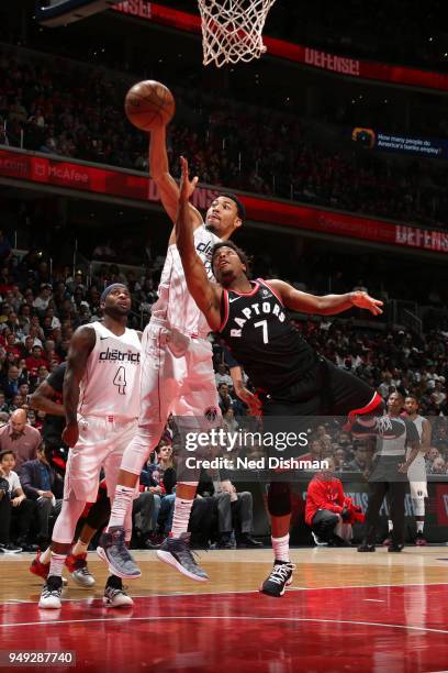 Otto Porter Jr. #22 of the Washington Wizards and Kyle Lowry of the Toronto Raptors reach for control of the ball during the game between the two...