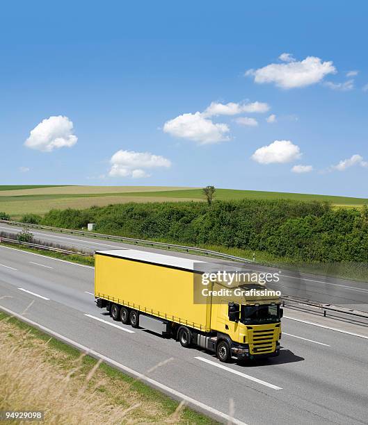 blue sky over yellow truck on a highway - skane stockfoto's en -beelden