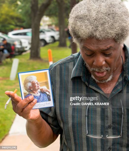 Well wisher holds up a memorial card he was given after viewing former First Lady Barbara Bush's casket lying in repose at St. Martin's Episcopal...