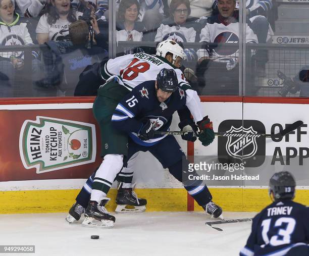 Matt Hendricks of the Winnipeg Jets checks Jordan Greenway of the Minnesota Wild in Game Five of the Western Conference First Round during the 2018...