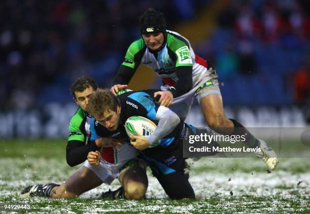 Mathew Tait of Sale is tackled by Nick Evans and George Lowe of Harlequins during the Heineken Cup match between Sale Sharks and Harlequins at...