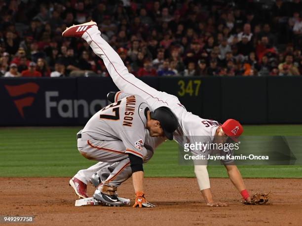 Andrelton Simmons of the Los Angeles Angels of Anaheim us upended by Kelby Tomlinson of the San Francisco Giants at he completes a double play in the...