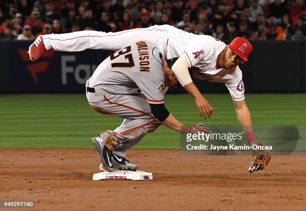 Andrelton Simmons of the Los Angeles Angels of Anaheim us upended by Kelby Tomlinson of the San Francisco Giants at he completes a double play in the...