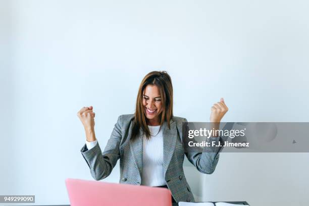 business woman with expression of triumph in the office - celebrating success stock pictures, royalty-free photos & images