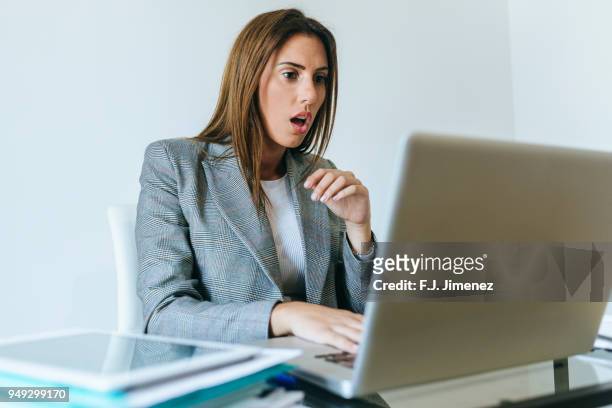 surprised business woman looking at the laptop - shocked stock pictures, royalty-free photos & images