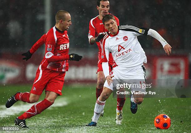 Mike Frantz of Nuernberg is defended by Miso Brecko and Petit of Koeln during the Bundesliga match between 1. FC Koeln and 1. FC Nuernberg at...