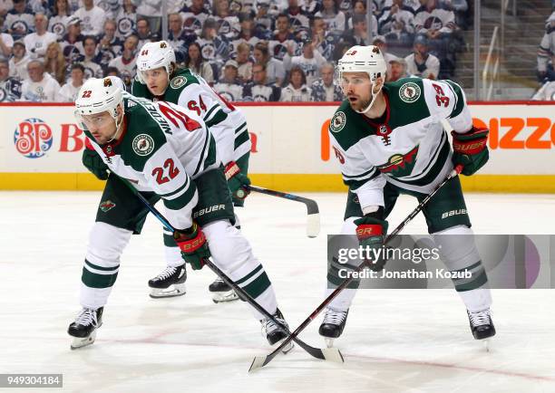 Nino Niederreiter, Mikael Granlund and Nate Prosser of the Minnesota Wild get set during a third period face-off against the Winnipeg Jets in Game...