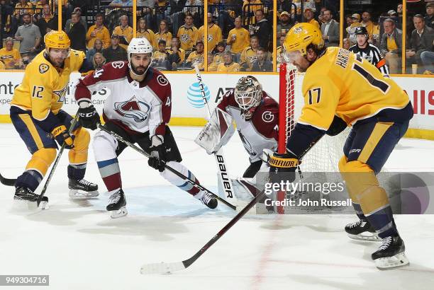 Andrew Hammond and Mark Barberio of the Colorado Avalanche eye the puck on the stick of Scott Hartnell of the Nashville Predators as Mike Fisher...