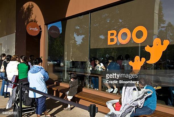 Customers stand outside in line to buy cupcakes at a Sprinkles Cupcakes store in Palo Alto, California, U.S., on Monday, Oct. 20, 2008. Candace and...