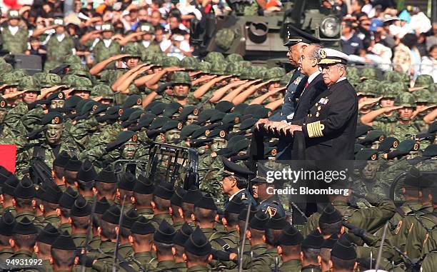 Felipe Calderon, Mexico's president, center, is flanked by Guillermo Galvan, defense minister, left, Mariano Francisco, minister of the navy, while...