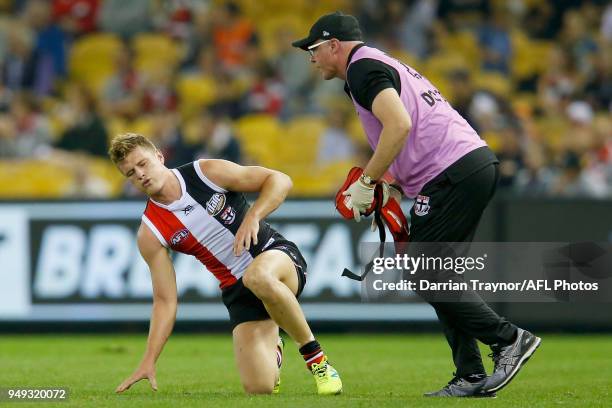 Jack Newnes of the Saints is helped by a trainer after colliding with Dawson Simpson of the Giants during the round five AFL match between the St...