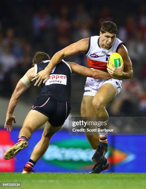 Jonathon Patton of the Giants is tackled by Luke Dunstan of the Saints during the round five AFL match between the St Kilda Saints and the Greater...