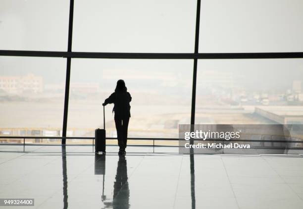 silhouette of travelers in airport - airport waiting stock pictures, royalty-free photos & images