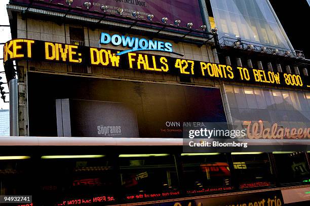 The Dow Jones ticker in Times Square displays news about the Dow closing below 8,000 at the end of the trading day in New York, U.S., on Wednesday,...