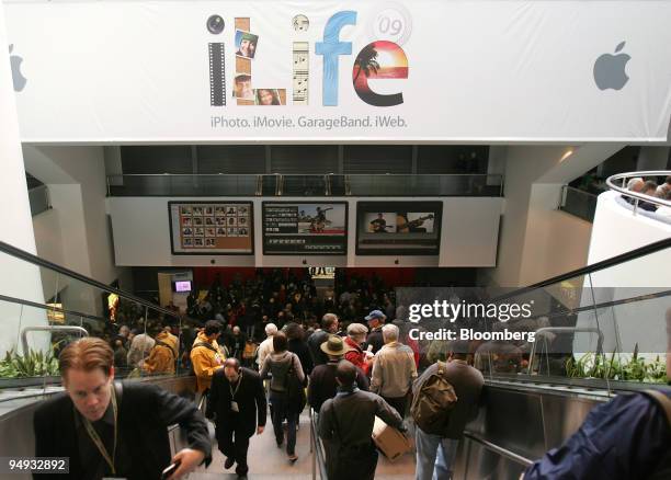 Apple MacWorld conference attendees walk into the convention hall next to a Apple iLife '09 poster during the conference in San Francisco,...