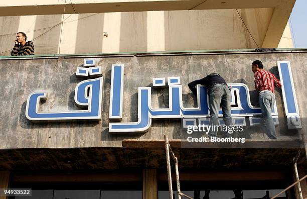 Workers make adjustments on an Egytrav travel agency sign in Cairo, Egypt, on Thursday, Nov. 27, 2008. Egypt's unemployment rate fell to 8.4 percent...