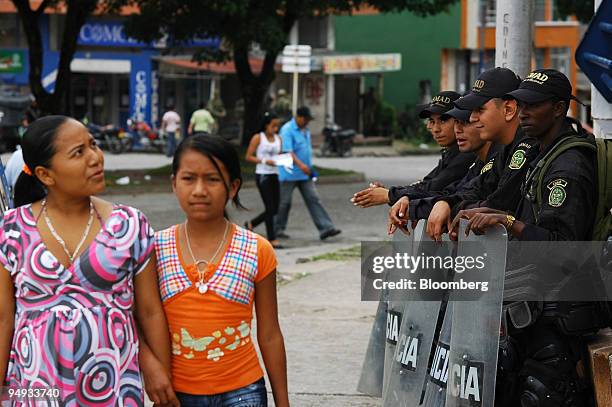 Colombian riot police guard the burned out offices of a pyramid scheme in Mocoa, Colombia, on Dec. 2, 2008. More than three million Colombians may...