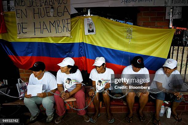 Group of women on a hunger strike sit chained to the shuttered doors of DMG SA in Mocoa, Colombia, on Dec. 2, 2008. The Colombian government alleges...