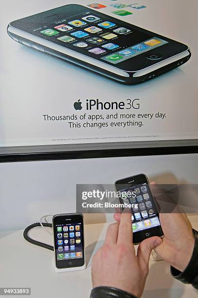 Customer looks over an Apple iPhone 3G at the Best Buy store in Orem, Utah, U.S., Jan. 21, 2009. Apple Inc. Reported an increase in first-quarter...