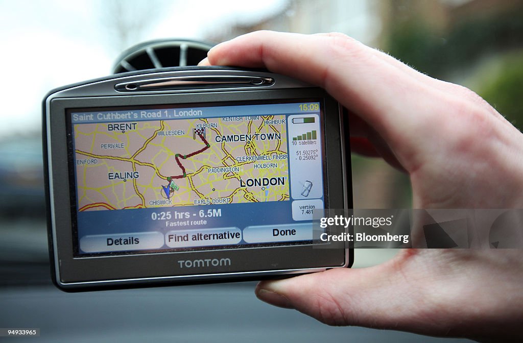 A driver adjusts his TomTom navigation system on a vehicle w