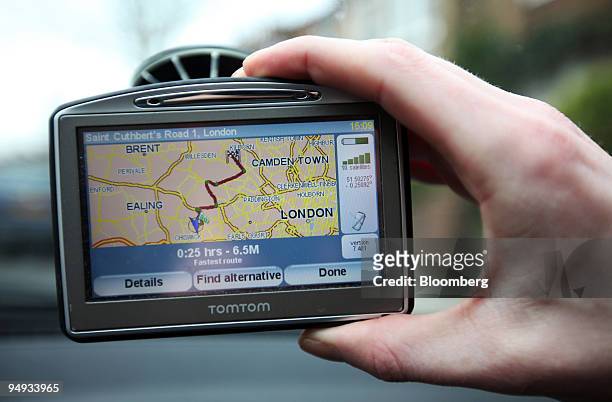 Driver adjusts his TomTom navigation system on a vehicle windscreen in London, U.K., on Monday, Feb. 23, 2009. TomTom NV, Europe's largest maker of...