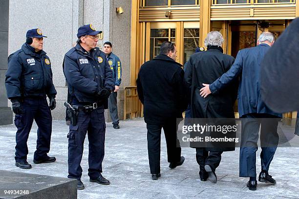 Bernard Madoff, founder of Bernard L. Madoff Investment Securities LLC, second from the right, is escorted into federal court in New York, U.S., on...