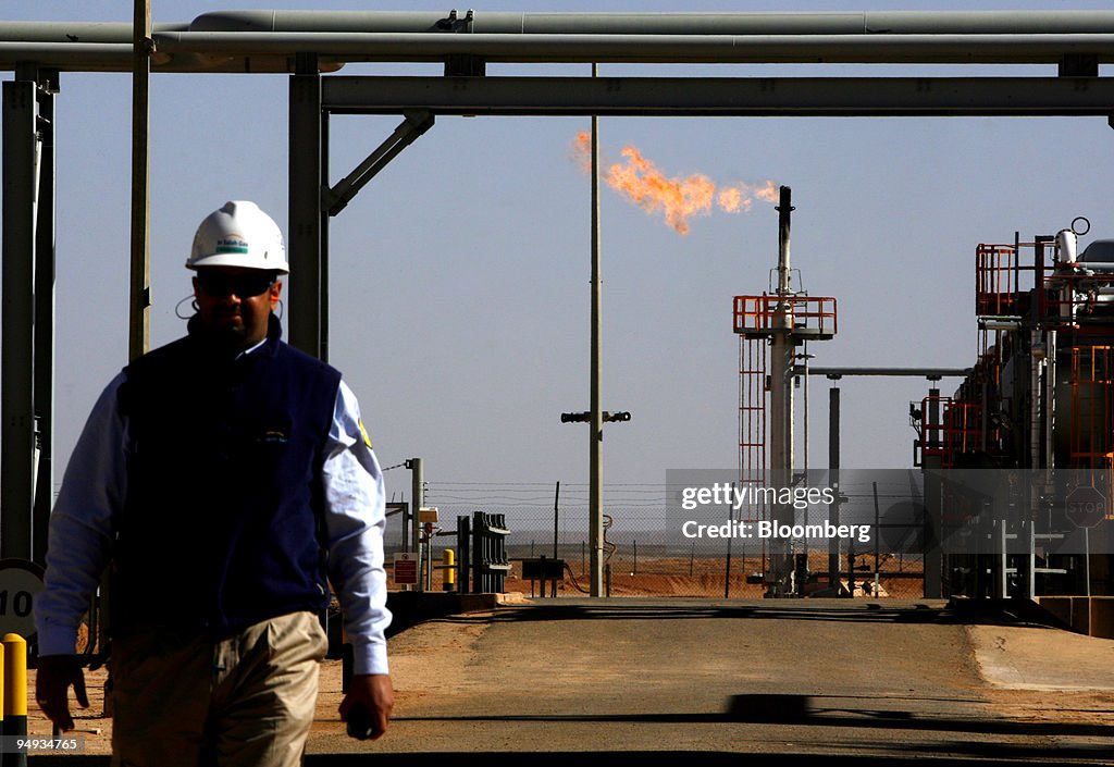 An employee walks in front of a gas flare at the In Salah Ga