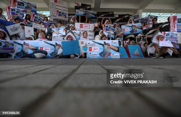 Activists wearing shark costumes take part in a protest against the use of shark's fins in food in Hong Kong on April 21, 2018. - About 50 activists...