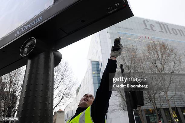 Frederic Cardon, a JCDecaux employee, scans an advertising panel in Paris, France, on Wednesday, Jan. 22, 2009. The company releases its earnings...