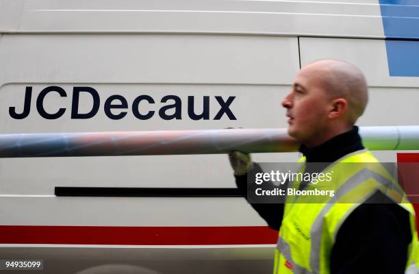 Frederic Cardon, a JCDecaux employee, carries a rolled-up advertising poster in Paris, France, on Wednesday, Jan. 22, 2009. The company releases its...