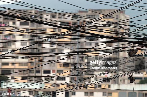 Power lines hang in the 23 de Enero neighborhood of Caracas, Venezuela, on Saturday, Jan. 3, 2009. Venezuela may provide a useful first test for...