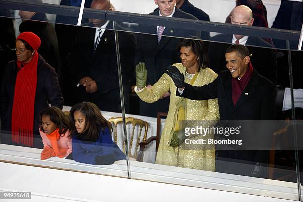 President Barack Obama, right, watches the inaugural parade pass from a reviewing stand at the White House, after being sworn in at the Capitol in...