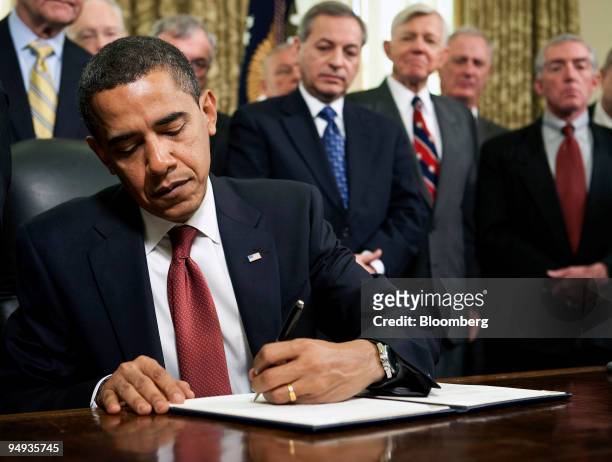President Barack Obama signs a series of executive orders pertaining to the Guantanamo Bay detention center, as retired Navy flag officers look on in...