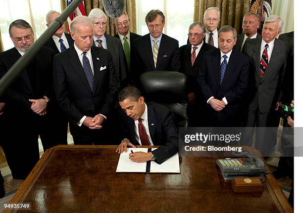 President Barack Obama signs a series of executive orders pertaining to the Guantanamo Bay detention center, as Vice President Joseph Biden, left and...