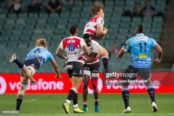 Lions player Andries Coetzee catches a high ball under pressure from Waratahs player Ned Hanigan at week 10 of the Super Rugby between The Waratahs...