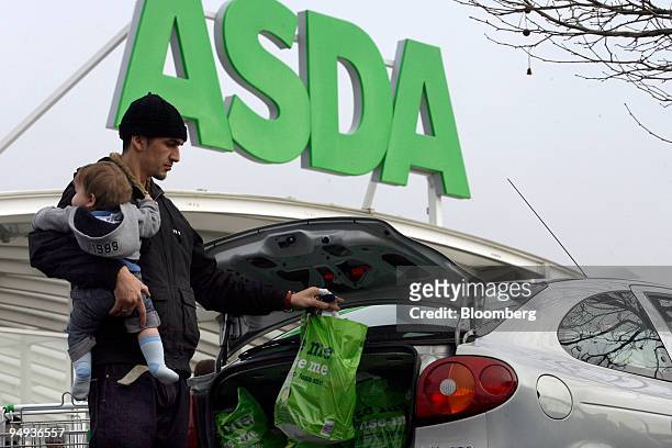 Jason Milligan loads shopping into his car at an Asda store in Leyton, east London, U.K., on Wednesday, Jan. 14, 2009. Asda, Wal-Mart Stores Inc.'s...