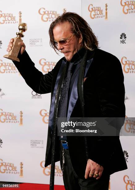 Actor Mickey Rourke holds his award for Best Performance by an Actor in a Motion Picture for "The Wrestler," backstage at the 66th Annual Golden...