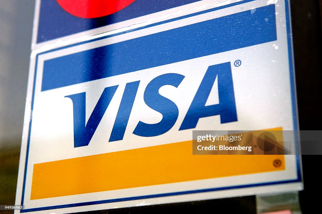 A Visa credit card sign is displayed in a store window in De